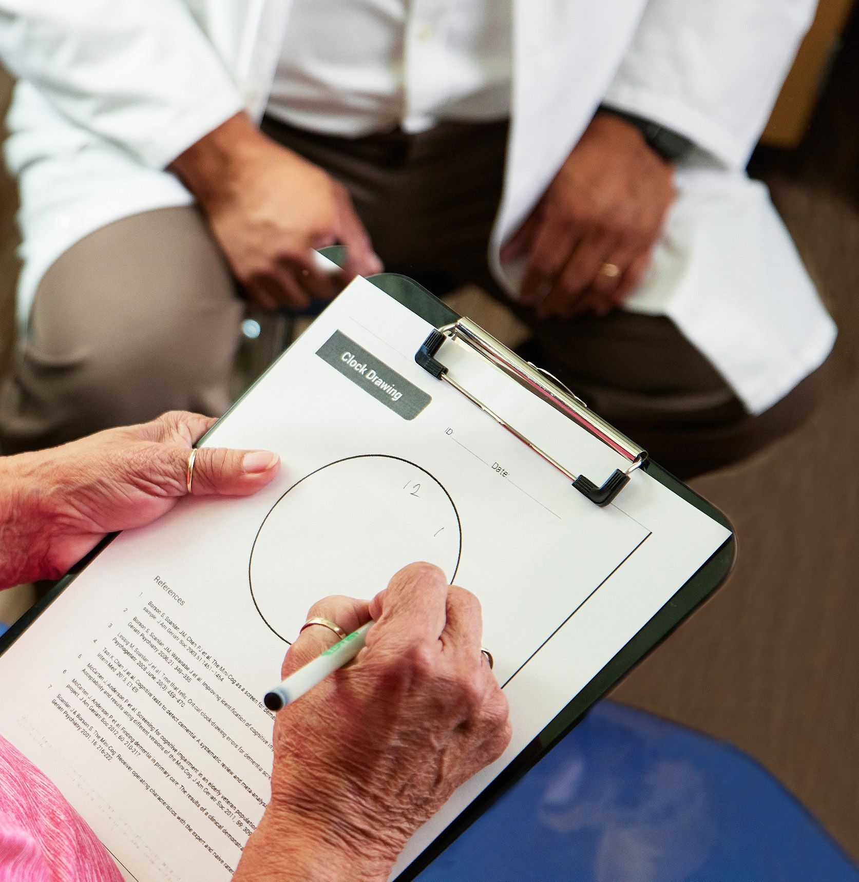 Woman taking clock drawing test in exam room