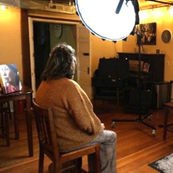 Seated woman being filmed for a documentary