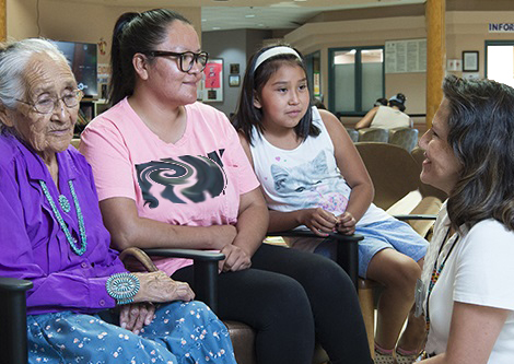 Three generations of women talking to a health provider