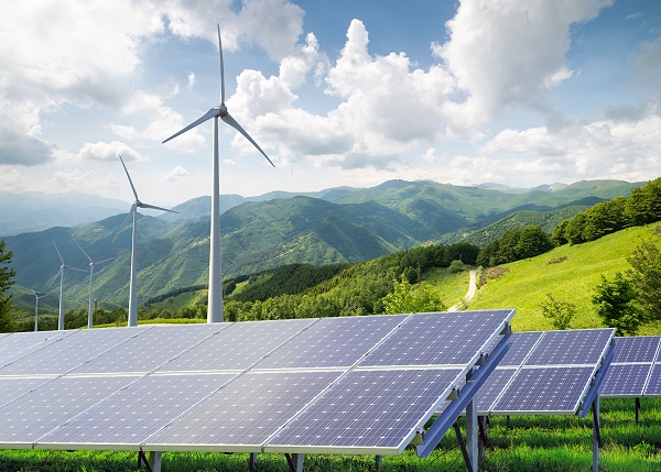 Environmental Sustainability - wind mill generators on a hill side with solar panels in the fore ground